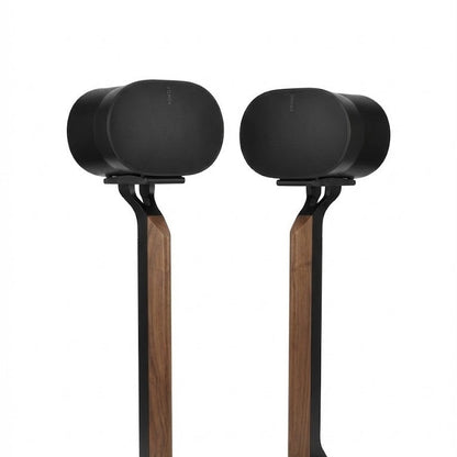 Pair of black speakers on wooden stands against a white background