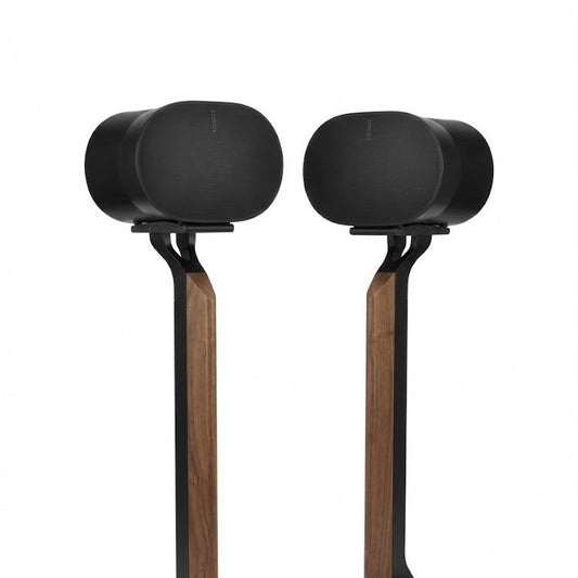 Pair of black speakers on wooden stands against a white background